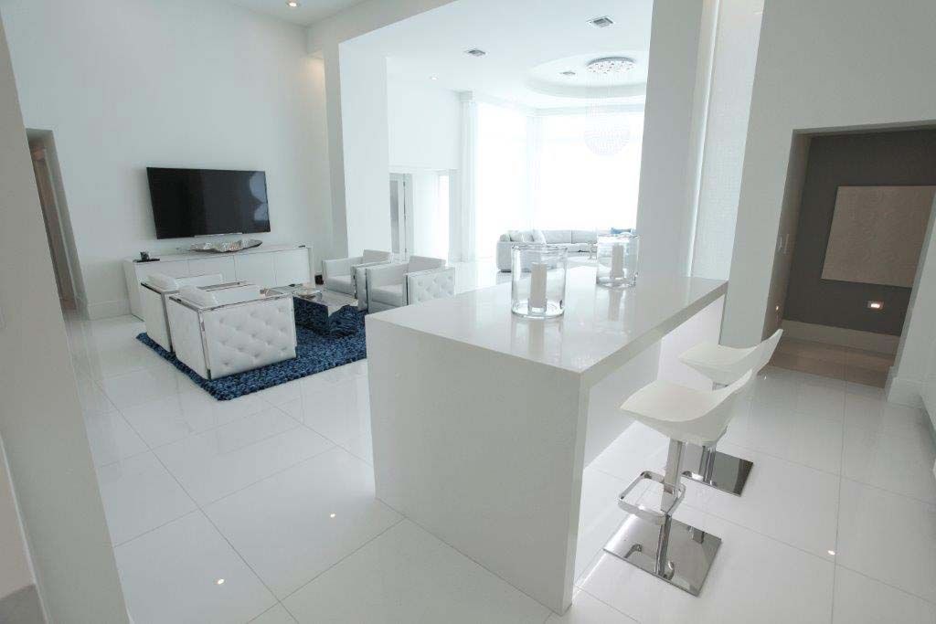 A white living room with a bar and a television.