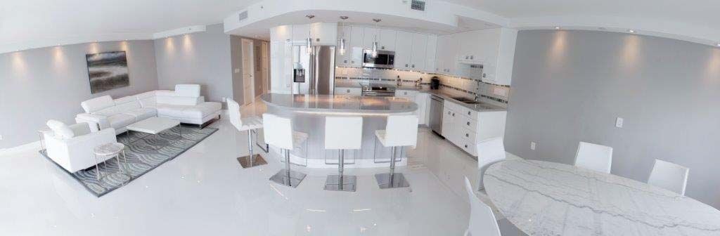 A panoramic view of a living room , dining room , and kitchen.