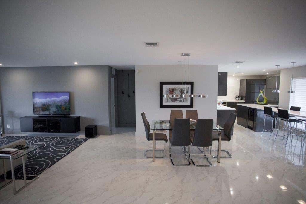 A living room with a dining room table and chairs and a television.