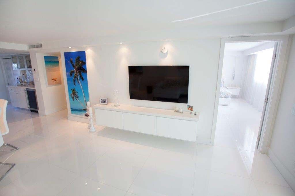 A living room with a flat screen tv on the wall.