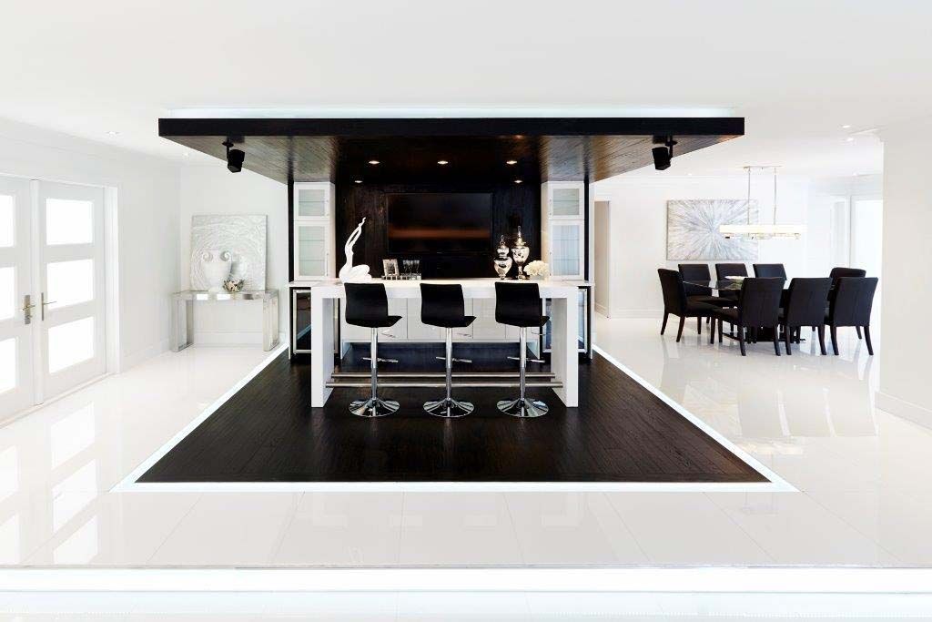 A black and white room with a bar and chairs