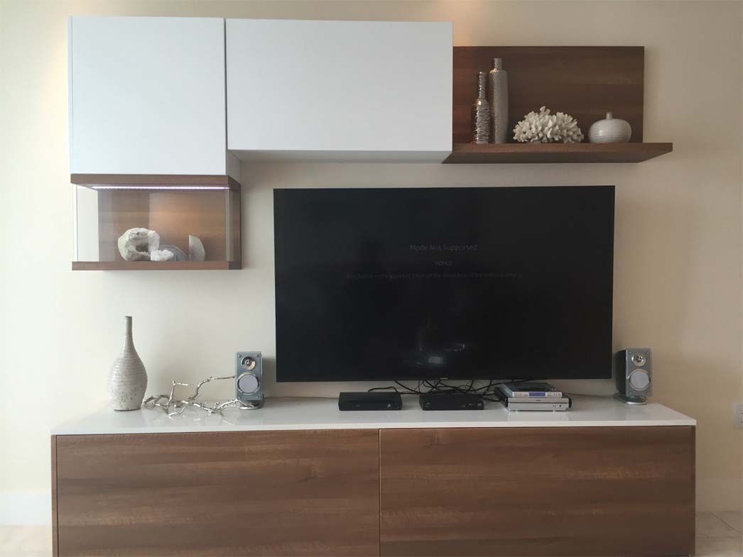 A living room with a flat screen tv and a wooden entertainment center