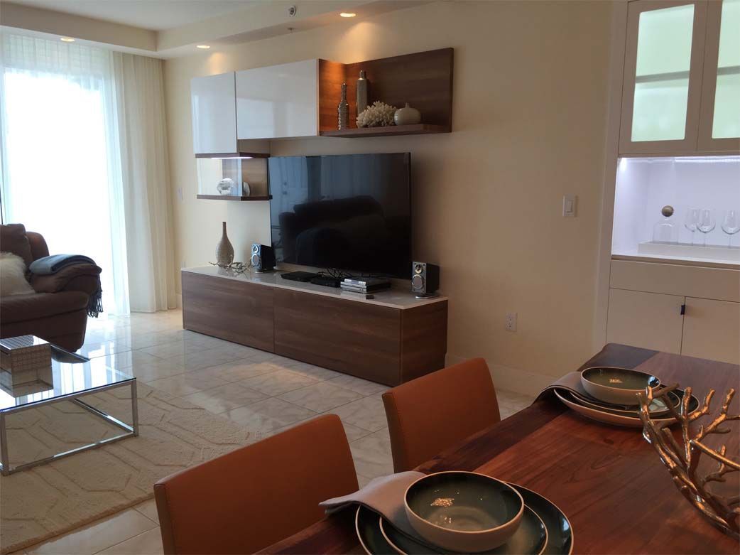 A living room with a table and chairs and a flat screen tv