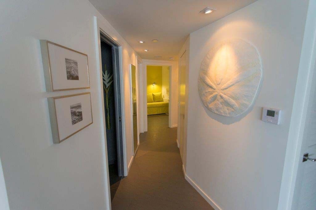 A hallway in a house with a sand dollar on the wall.
