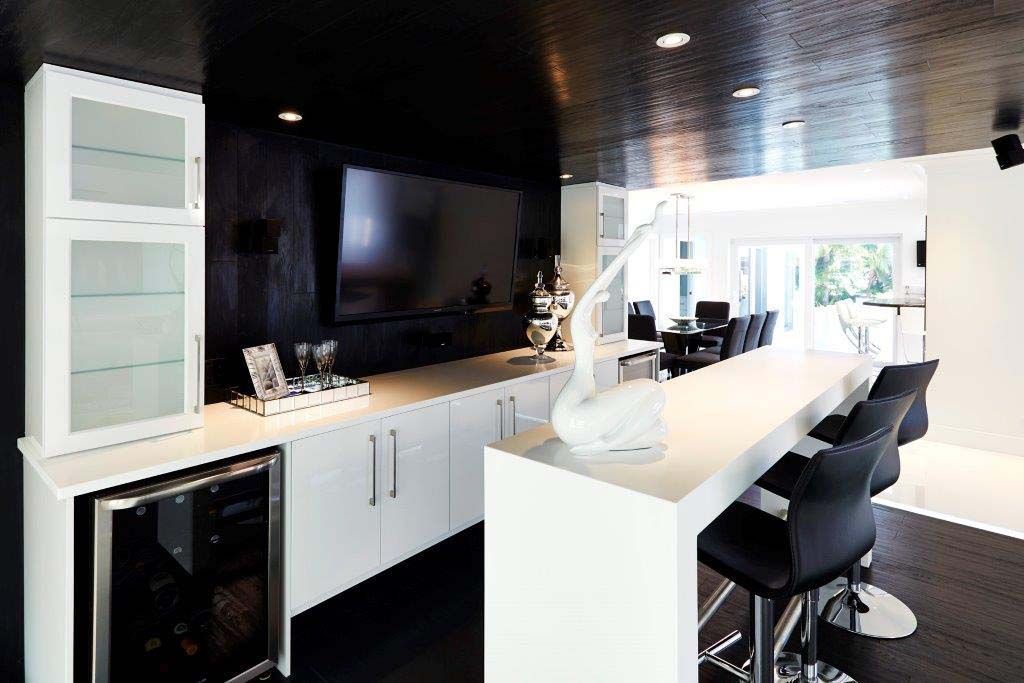 A black and white kitchen with a bar and stools