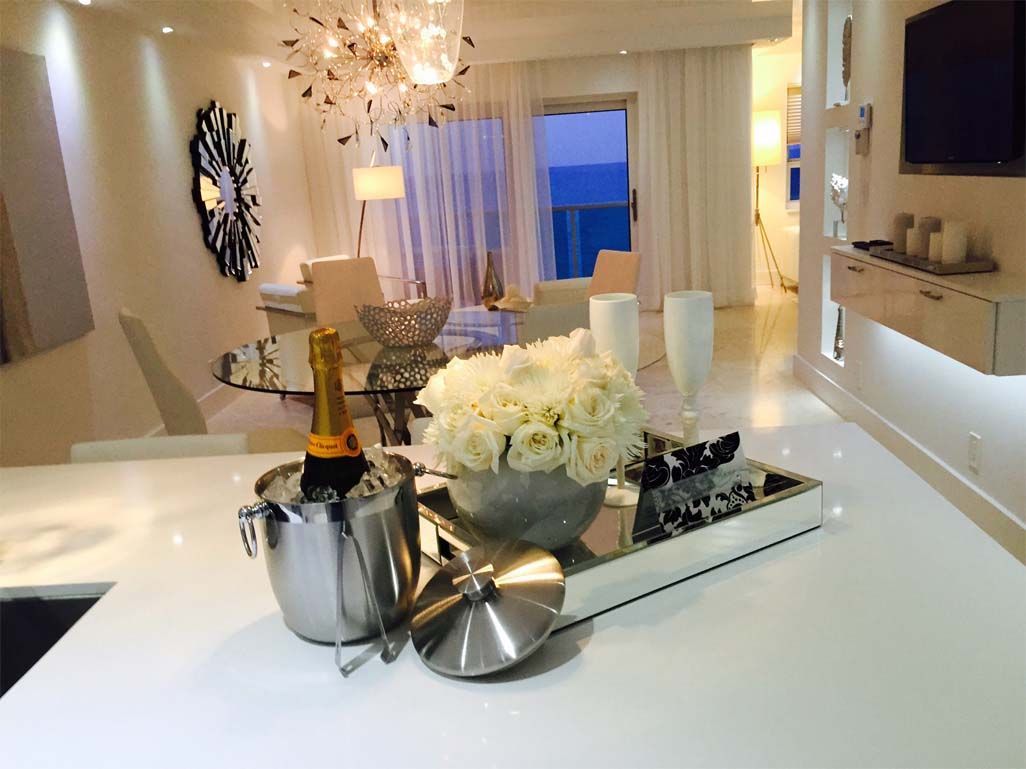 A bottle of champagne is in a bucket on a counter in a living room.