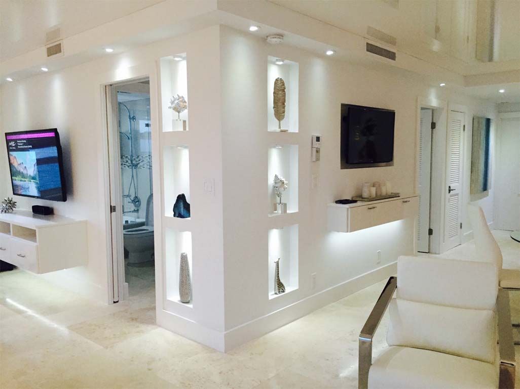 A living room with a television on the wall and a chair.