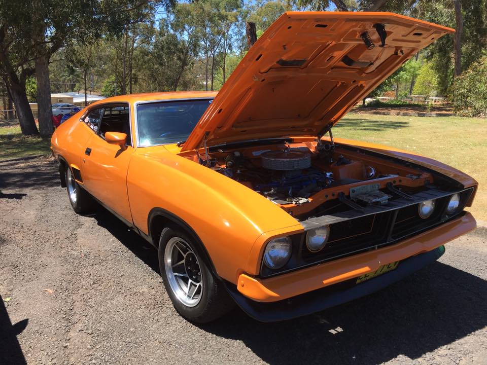 orange Ford muscle car with its hood open