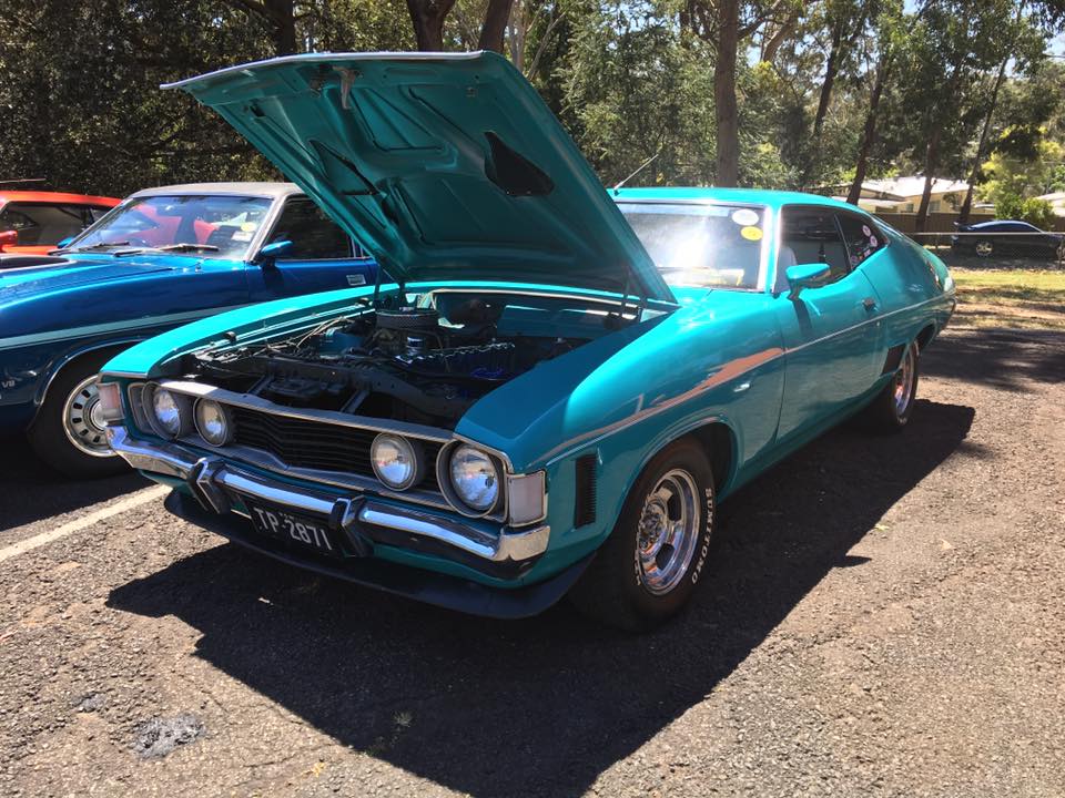 cyan Ford classic muscle car with its hood opened