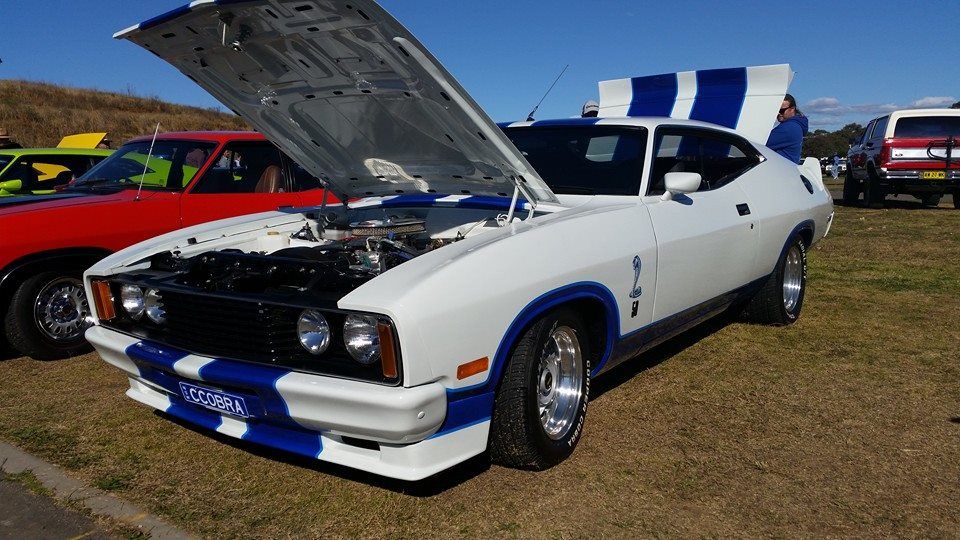 Ford classic muscle car (white color) with its hood open