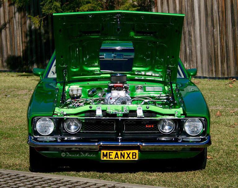 classic green Ford muscle car with its hood popped