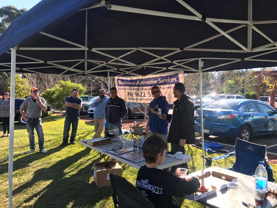 72-78 Ford V8 club NSW members standing behind a table