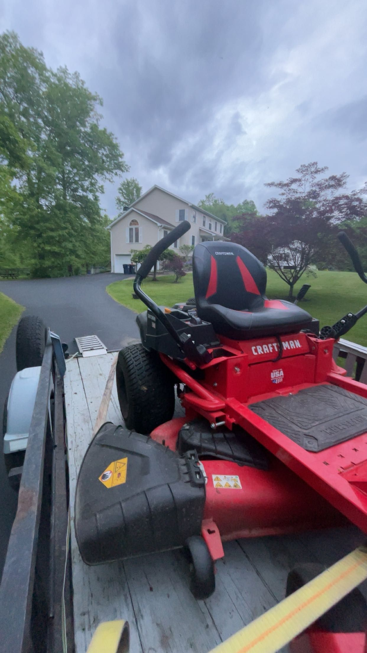 A man is mowing a lush green lawn with a lawn mower.