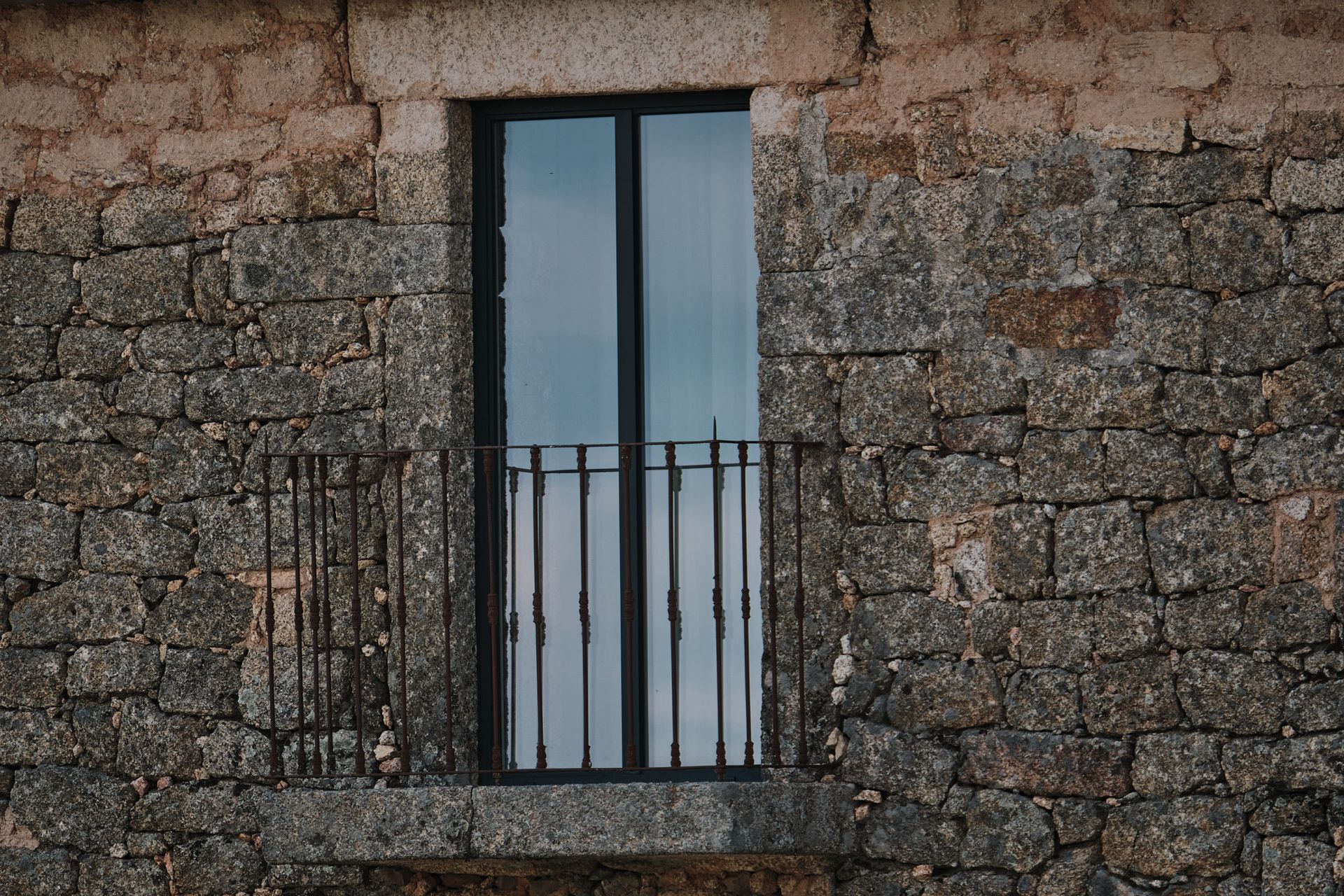 A stone building with a balcony and a window