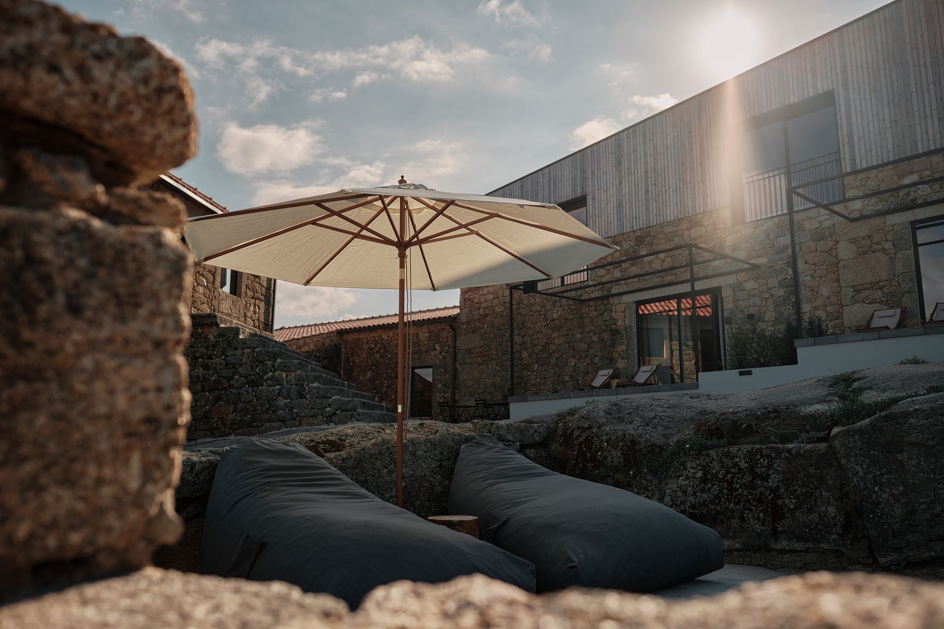 A white umbrella is sitting in front of a stone building.