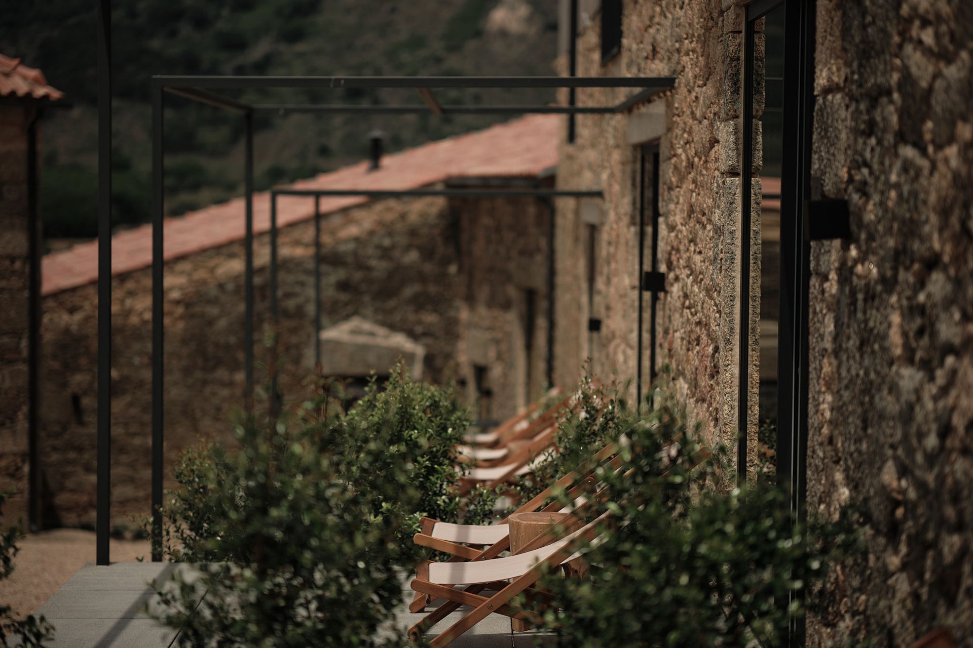 A row of chairs are lined up in front of a stone building.