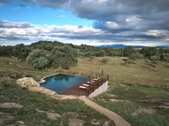 An aerial view of a swimming pool in the middle of a field.