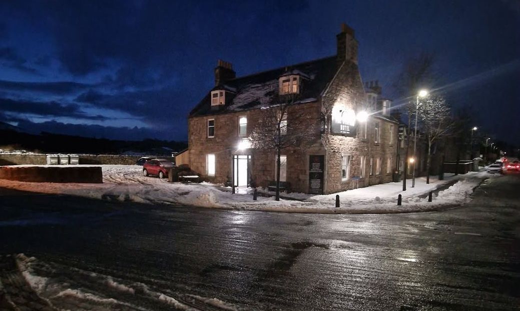 The brightly lit Station Hotel Insch in the first snowfall of winter 2025