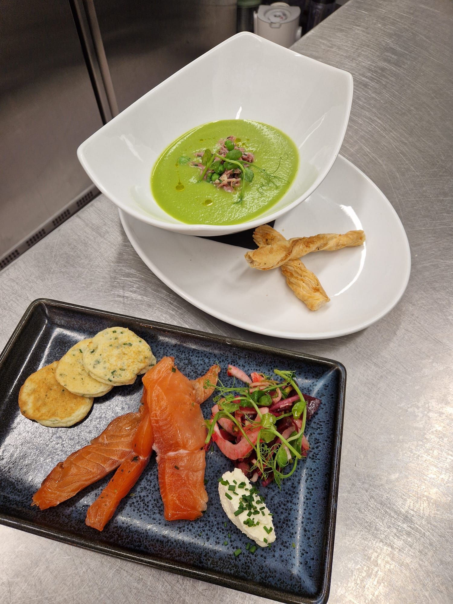 A bowl of Garden pea soup with truffle oil and a dish of Gin cured salmon