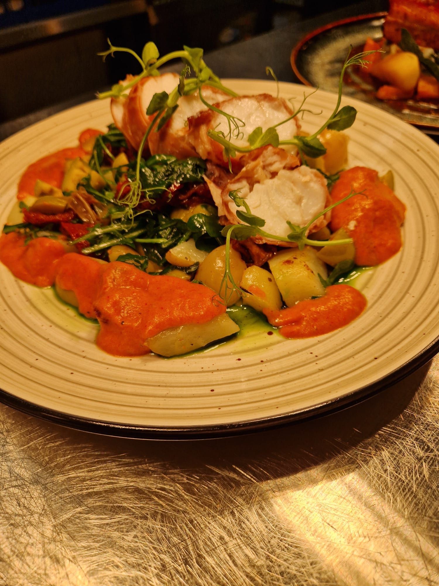 A plate containing monkfish wrapped in prosciutto