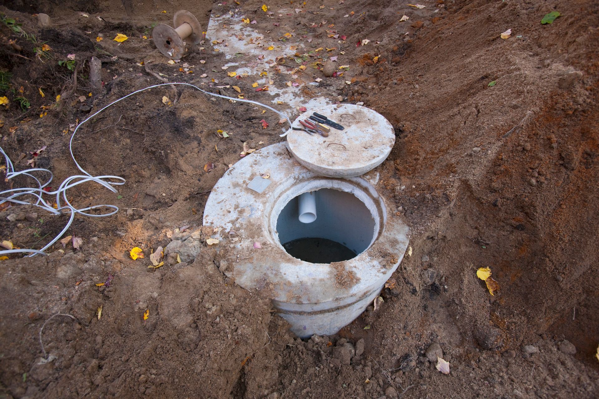A septic tank is sitting in the middle of a dirt field.