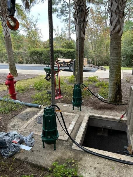 A man is pumping water into a manhole cover.
