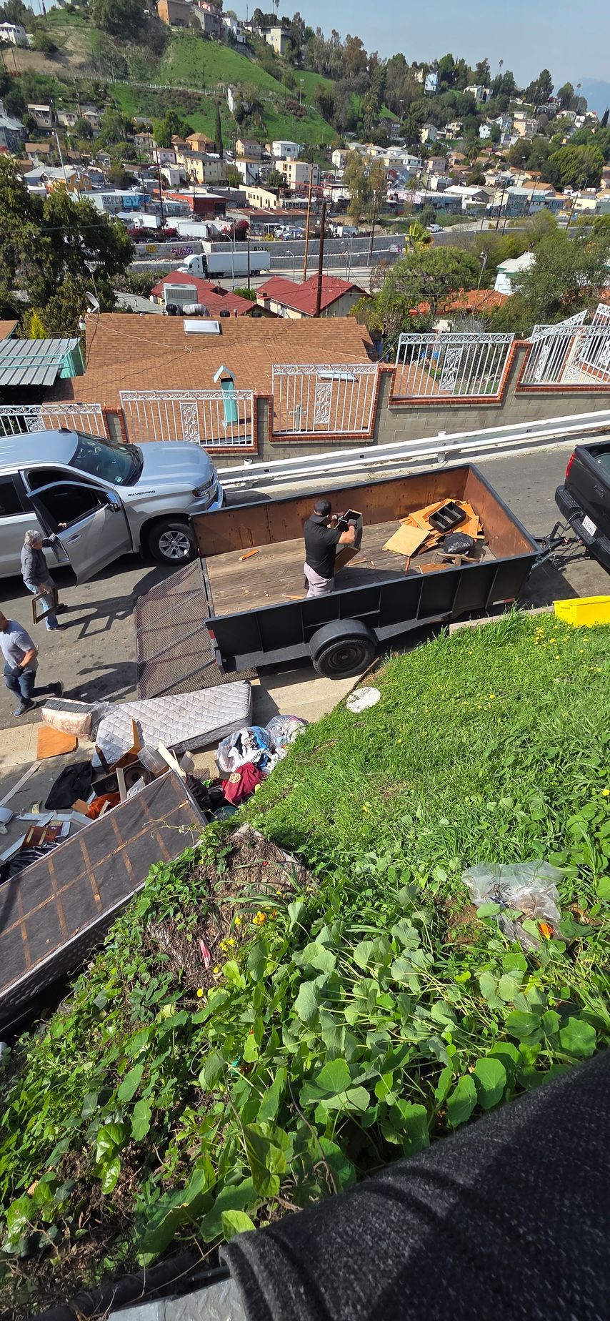 A car is parked on the side of the road next to a trailer.