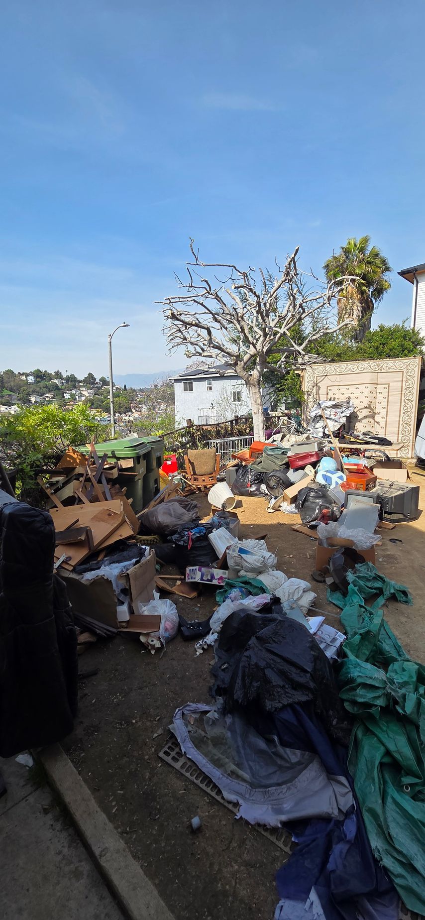 A pile of trash is sitting on the ground in a yard.