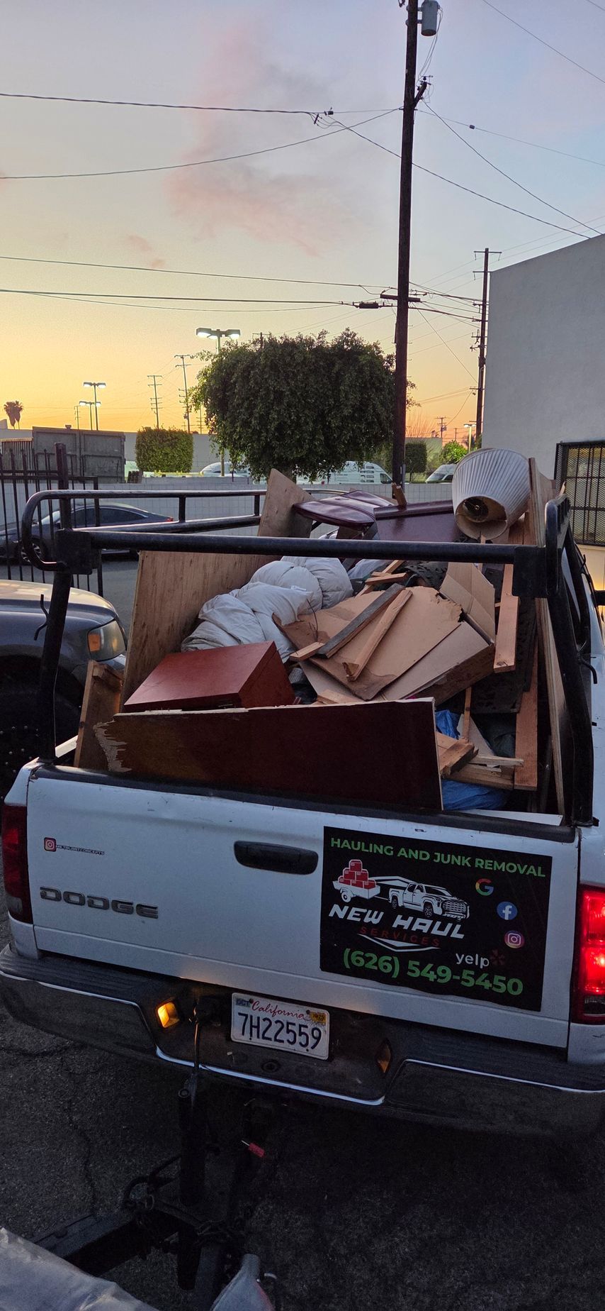 A white truck is filled with lots of junk in the back.
