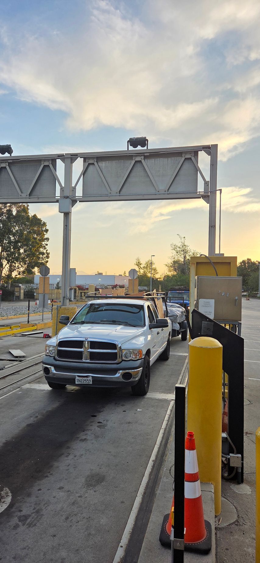 A white truck is parked next to a trailer in a parking lot.
