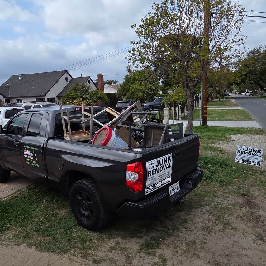 A junk removal truck is parked on the side of the road