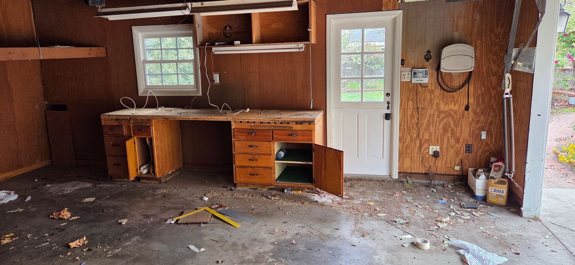 An empty garage with a sink , cabinets , and a door.
