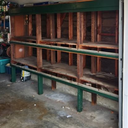 A wooden shelf with green trim in a garage