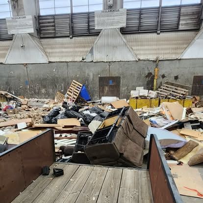 A warehouse filled with lots of cardboard boxes and trash.