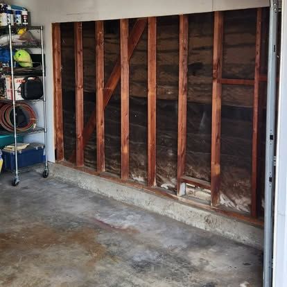 A garage with a wooden wall and a concrete floor