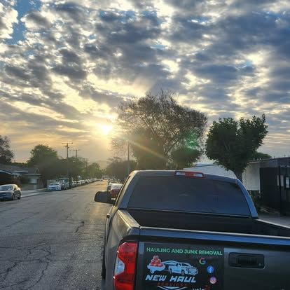 A truck is parked on the side of the road at sunset.
