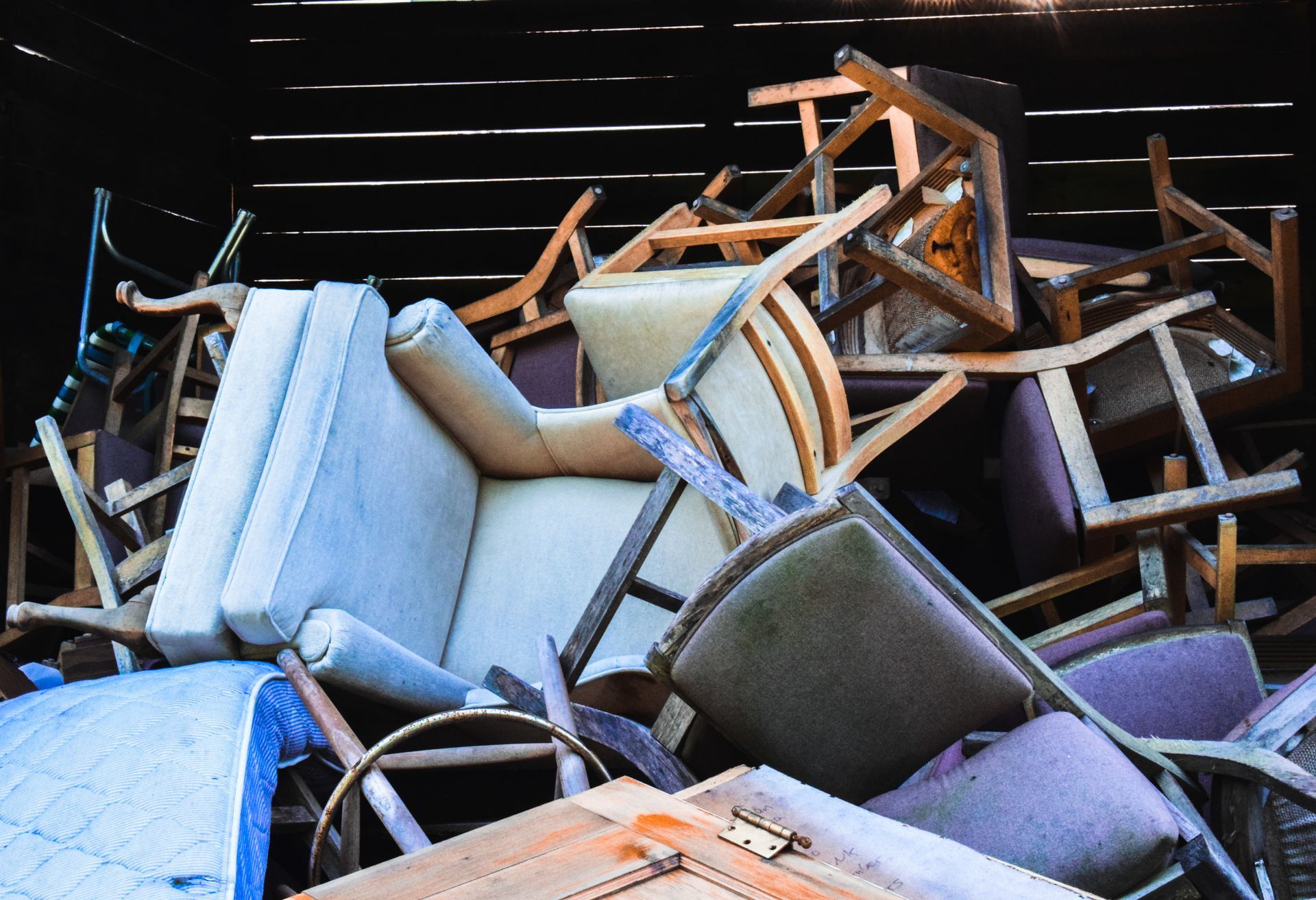 A pile of chairs and a couch are stacked on top of each other.