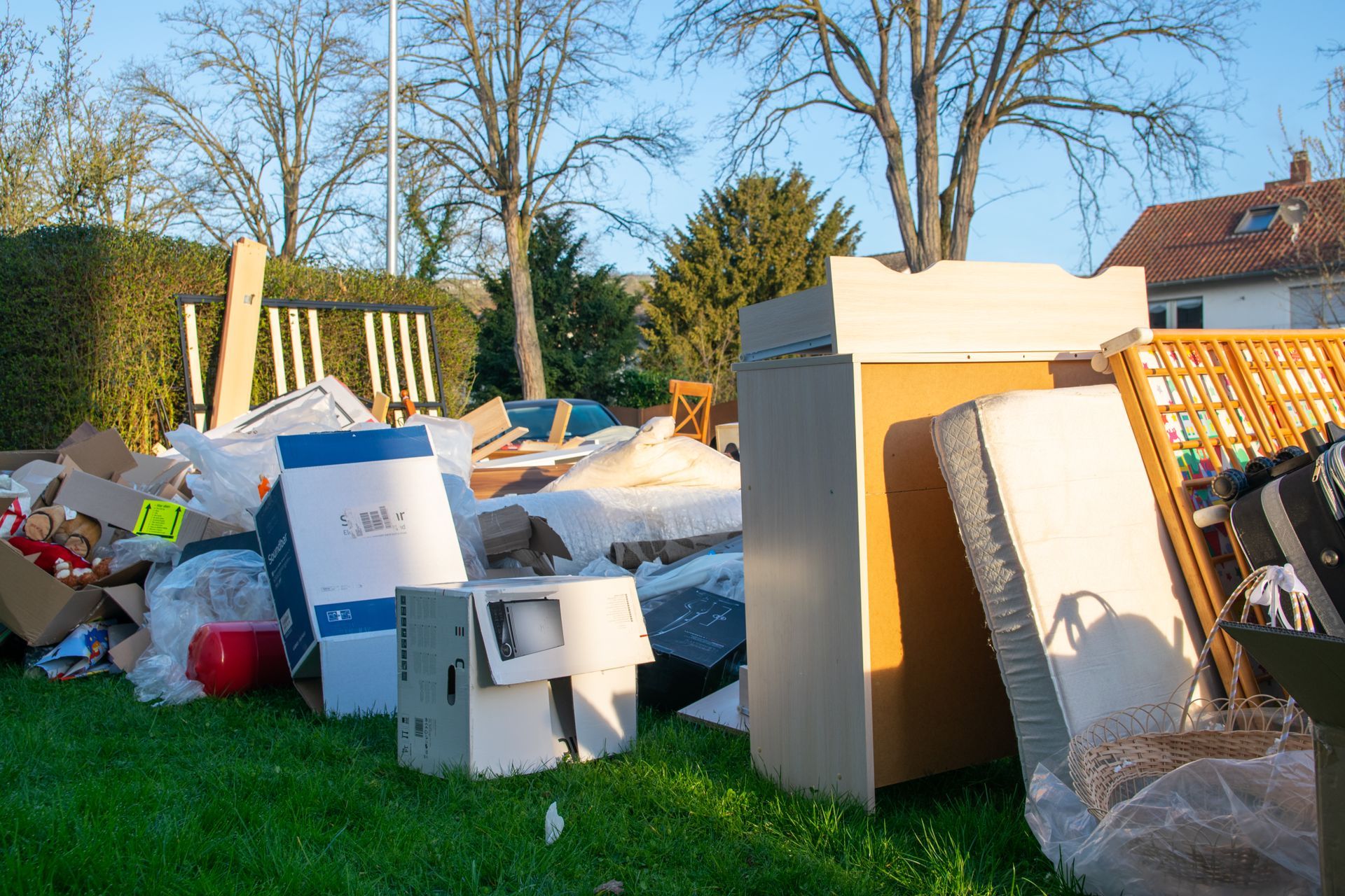 A pile of garbage is sitting on top of a lush green field.
