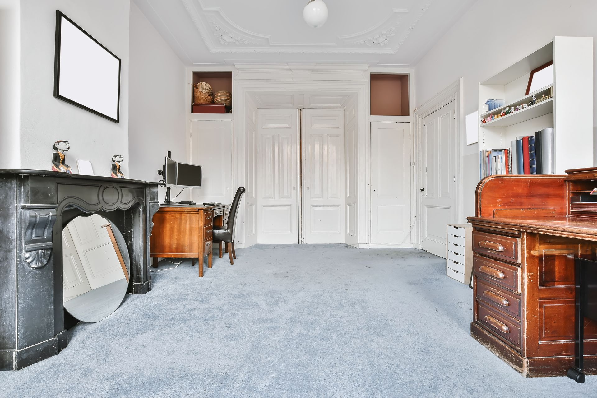 A living room with a fireplace and a desk