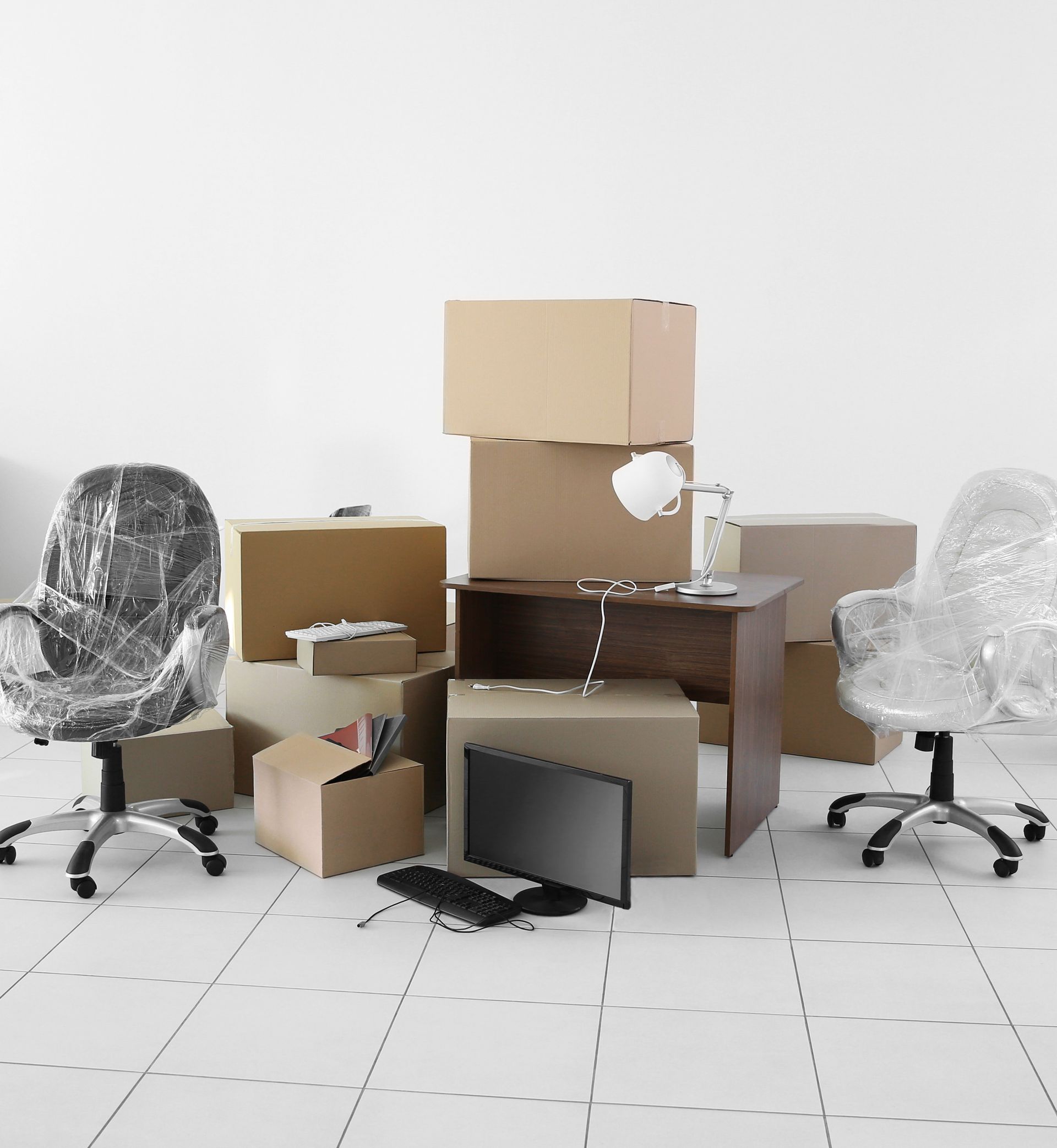 A room filled with boxes chairs and a desk