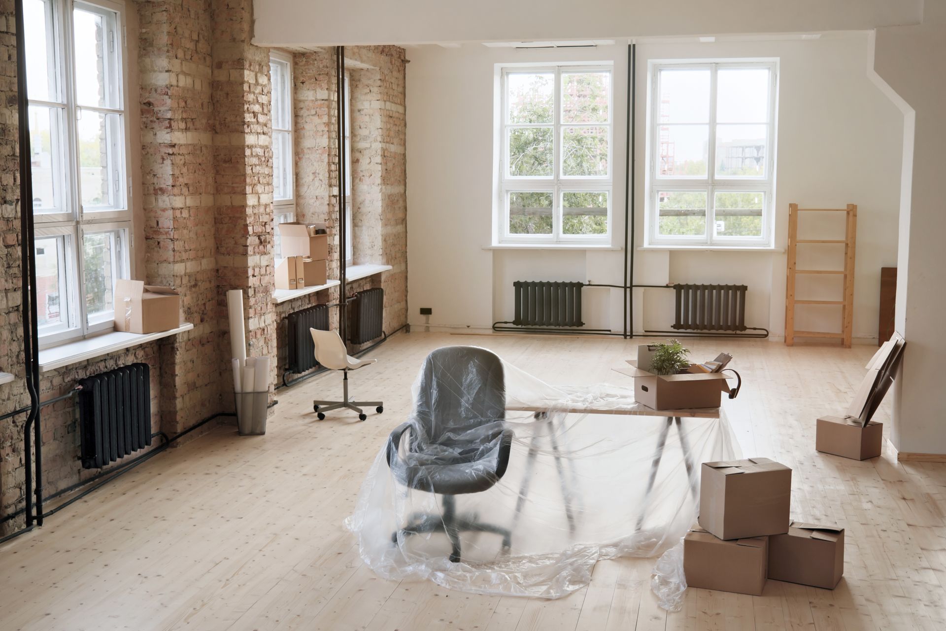 An empty room with a chair , desk , and boxes.