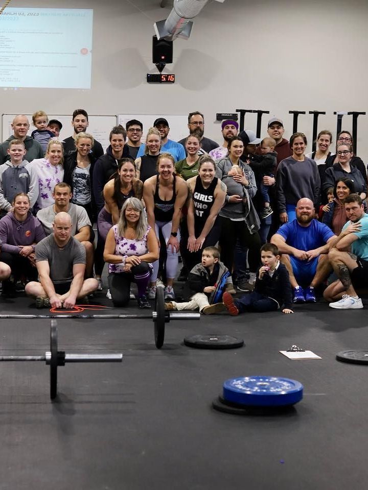 A large group of people are posing for a picture in a gym.