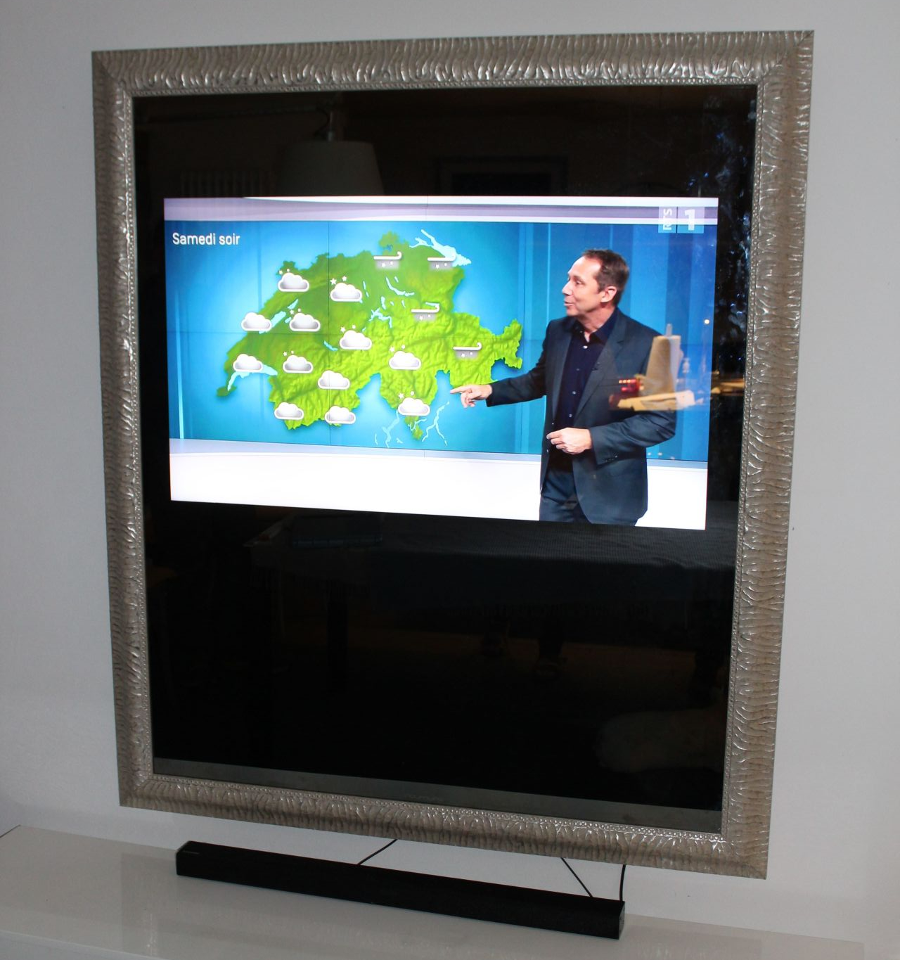 Un homme en costume se tient devant une carte indiquant la météo