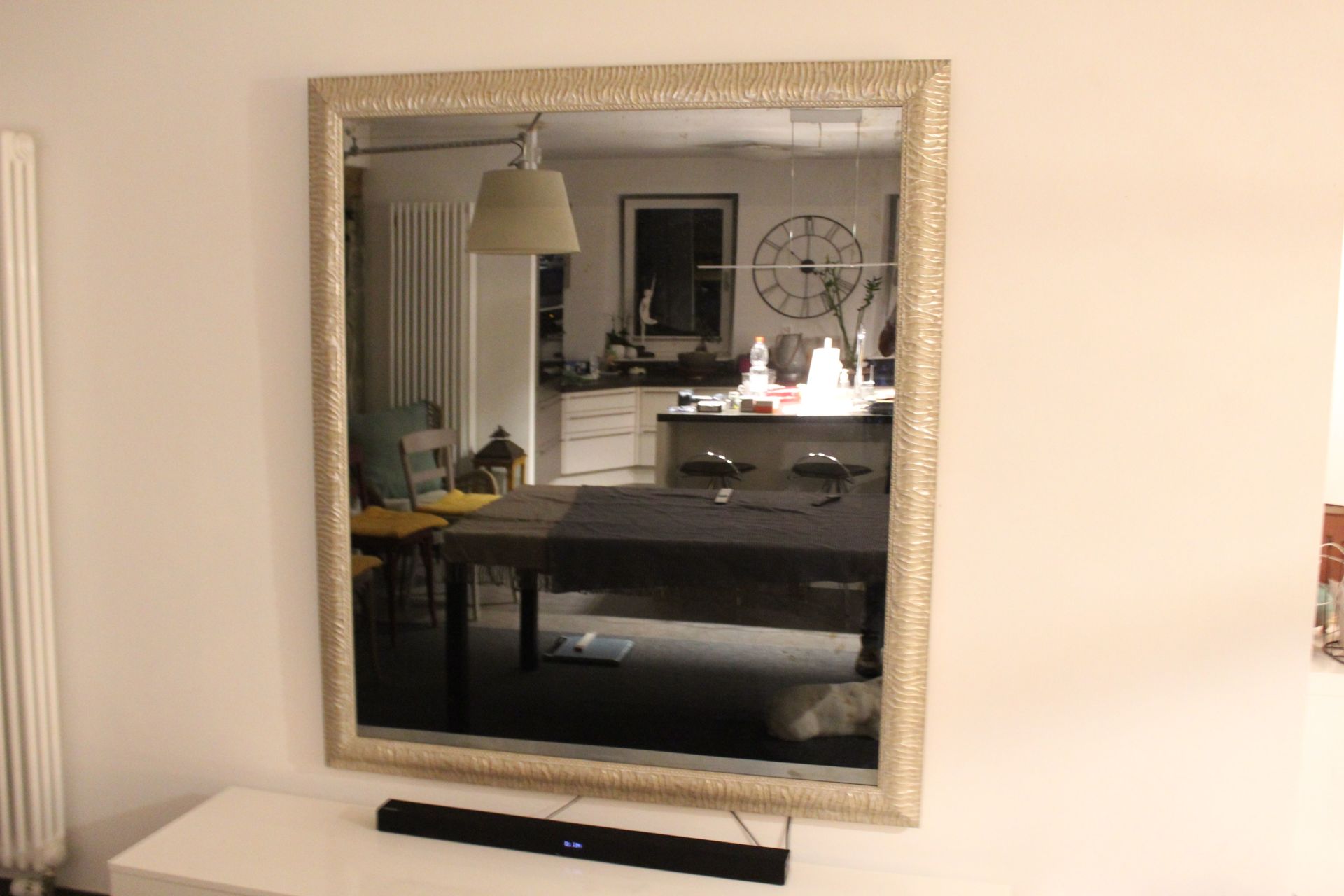 Un grand miroir est accroché au mur d'un salon