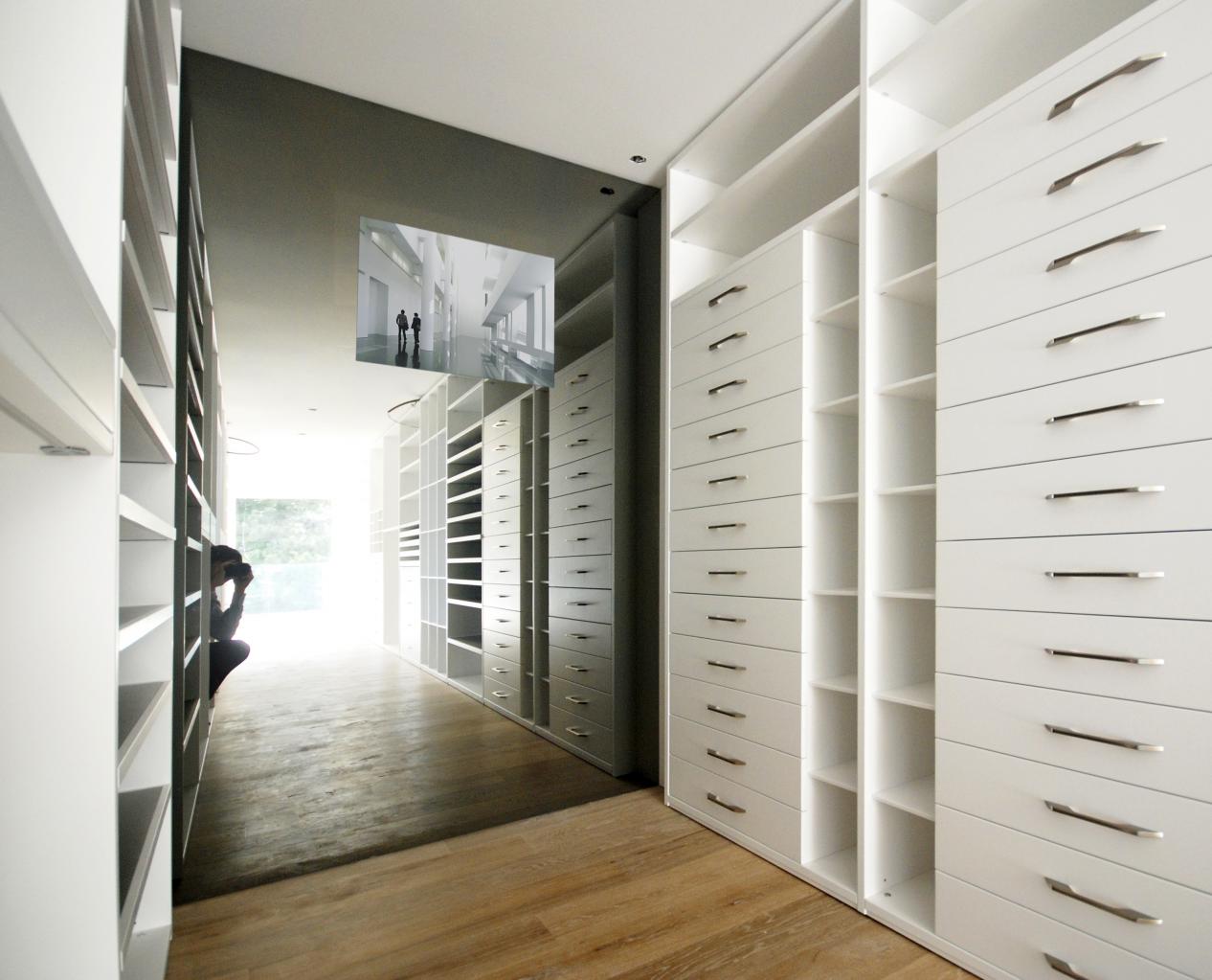 Un dressing avec de nombreuses étagères et tiroirs