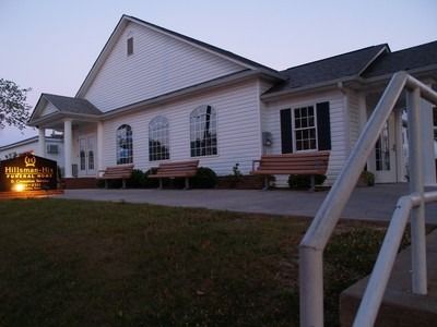 A white building with a sign that says hillman hall