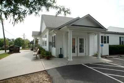 A white building with a parking lot in front of it