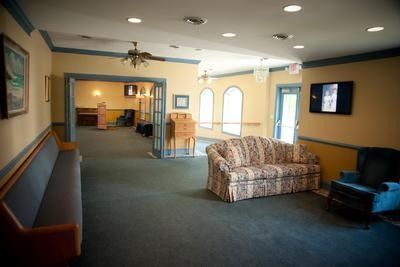 A living room with a couch , chairs , and a television.