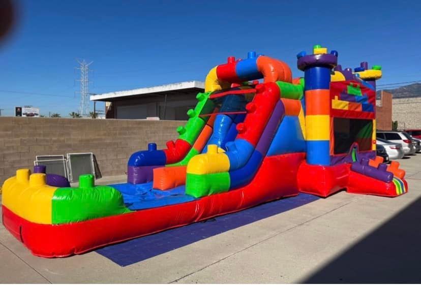 A colorful bouncy house is sitting on the side of the road.