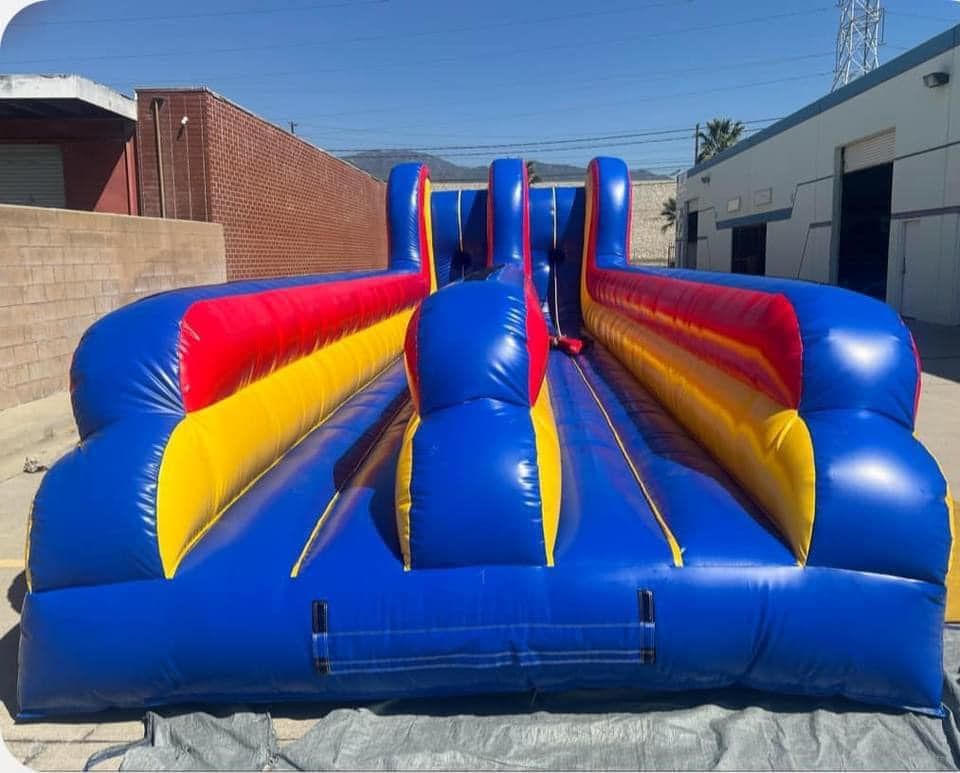 A large inflatable bungee run is sitting in front of a building.